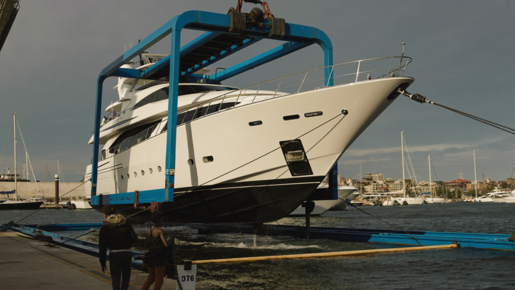 Yacht suspended in a travel-lift boat hoist at a marina boatyard