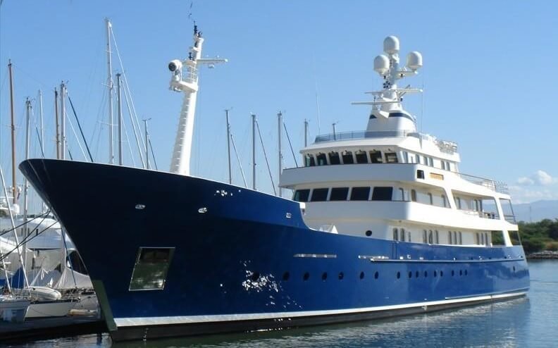Blue-hulled expedition yacht moored in a marina, an MTS Yachts client vessel